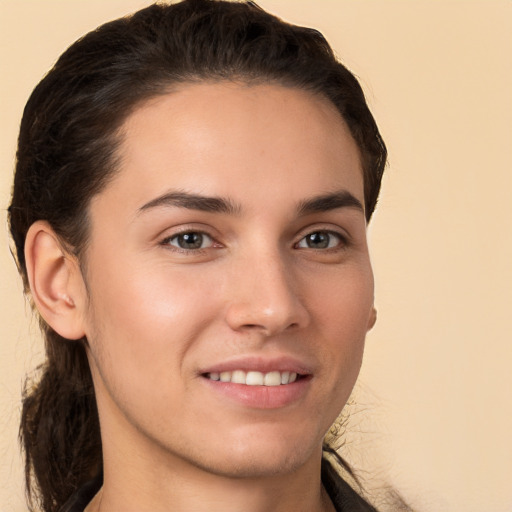 Joyful white young-adult male with long  brown hair and brown eyes