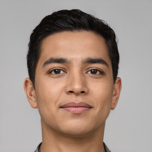 Joyful latino young-adult male with short  black hair and brown eyes