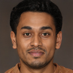 Joyful latino young-adult male with short  brown hair and brown eyes