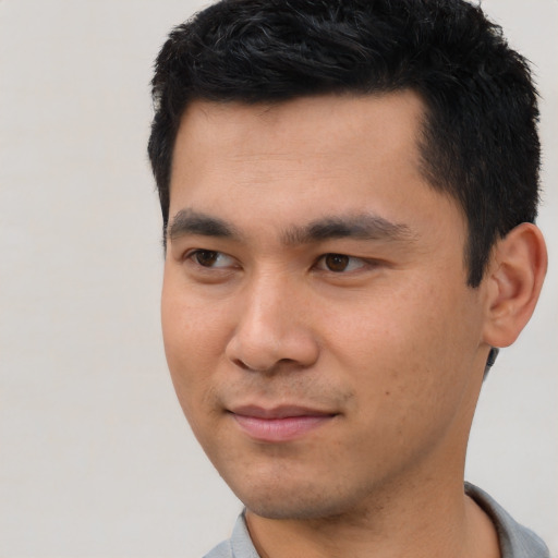 Joyful latino young-adult male with short  black hair and brown eyes