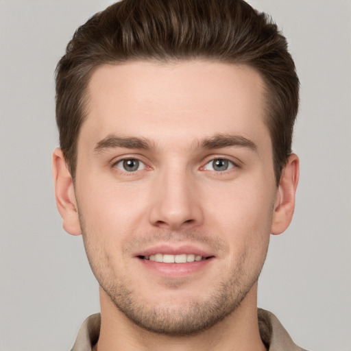 Joyful white young-adult male with short  brown hair and grey eyes