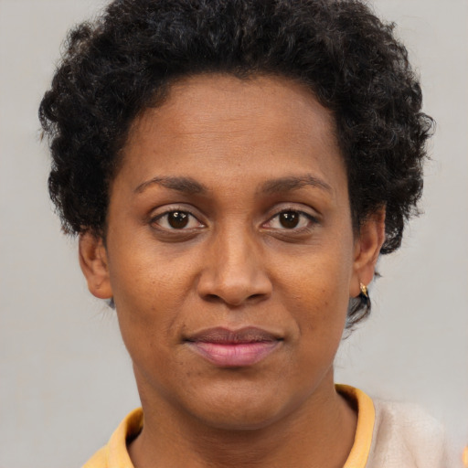 Joyful black young-adult female with short  brown hair and brown eyes