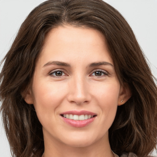 Joyful white young-adult female with long  brown hair and brown eyes