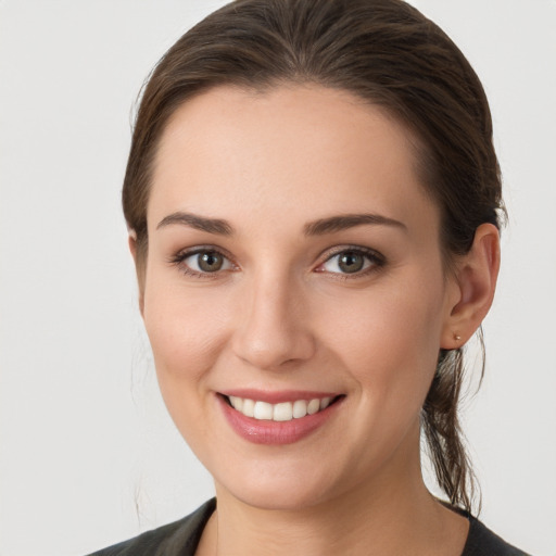 Joyful white young-adult female with medium  brown hair and grey eyes