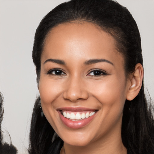 Joyful latino young-adult female with long  black hair and brown eyes