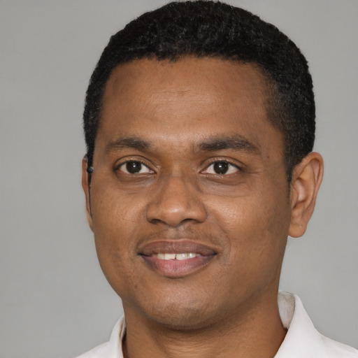 Joyful black young-adult male with short  black hair and brown eyes