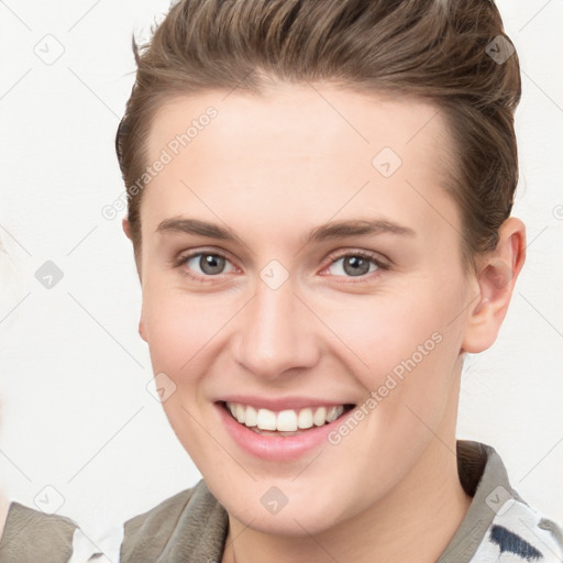 Joyful white young-adult female with short  brown hair and grey eyes