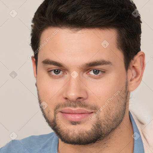 Joyful white young-adult male with short  brown hair and brown eyes