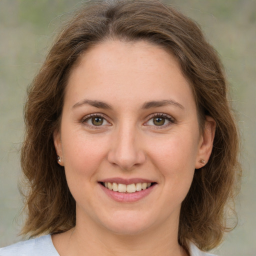 Joyful white young-adult female with medium  brown hair and green eyes