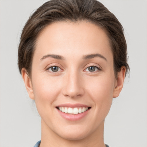 Joyful white young-adult female with short  brown hair and grey eyes