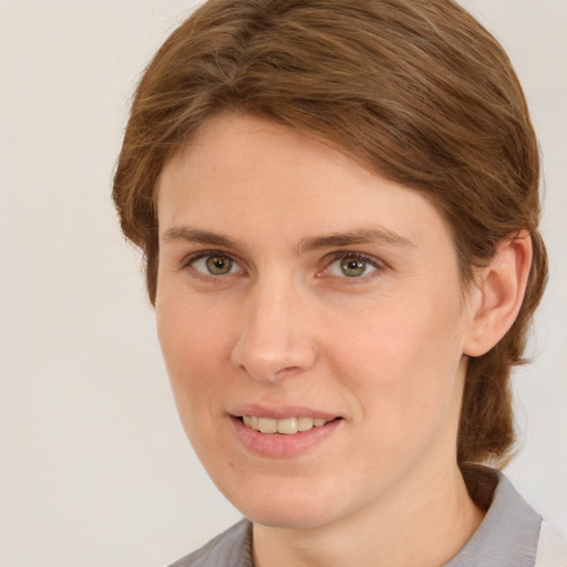 Joyful white young-adult female with medium  brown hair and green eyes