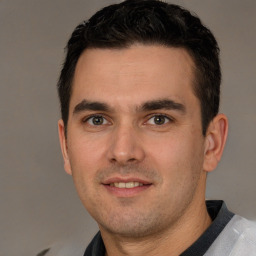 Joyful young adult male with brown eyes and short brown hair