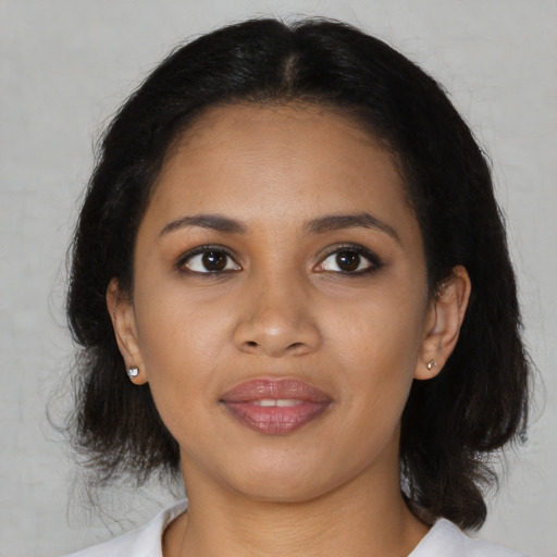 Joyful black young-adult female with medium  brown hair and brown eyes