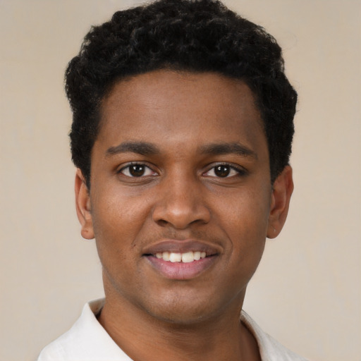 Joyful black young-adult male with short  black hair and brown eyes