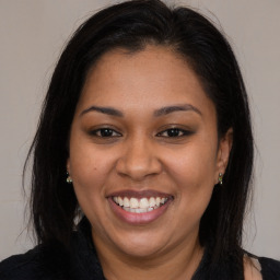 Joyful latino young-adult female with long  brown hair and brown eyes