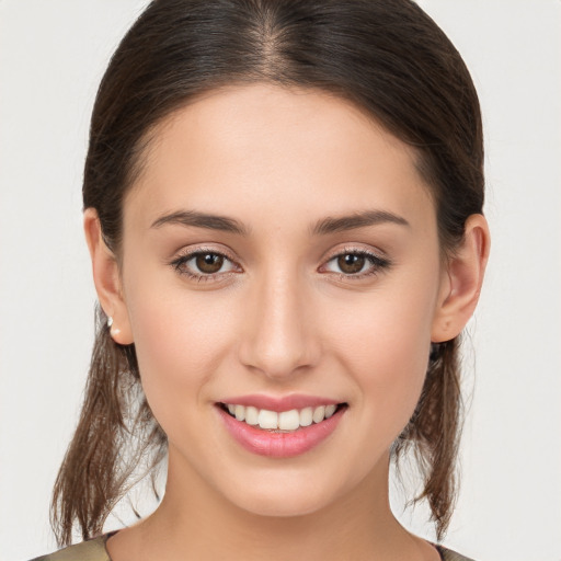 Joyful white young-adult female with long  brown hair and brown eyes