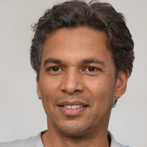 Joyful latino adult male with short  brown hair and brown eyes