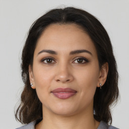 Joyful latino young-adult female with medium  brown hair and brown eyes