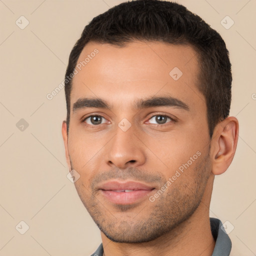 Joyful latino young-adult male with short  brown hair and brown eyes