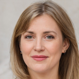 Joyful white adult female with long  brown hair and grey eyes