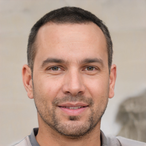 Joyful white young-adult male with short  brown hair and brown eyes