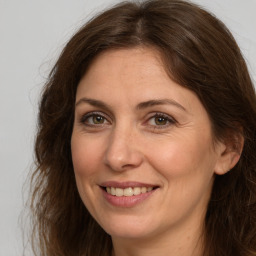 Joyful white adult female with long  brown hair and brown eyes