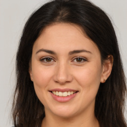 Joyful white young-adult female with long  brown hair and brown eyes