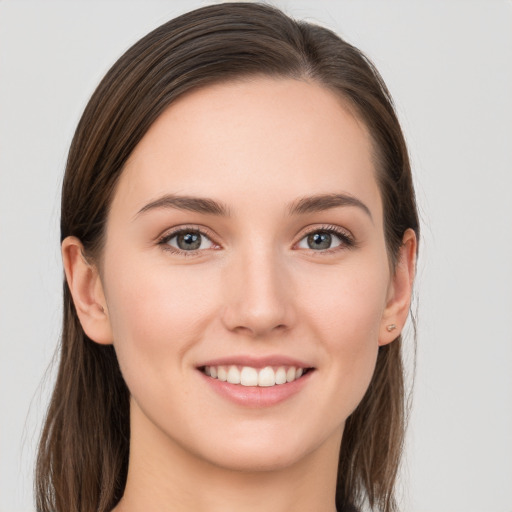 Joyful white young-adult female with long  brown hair and grey eyes