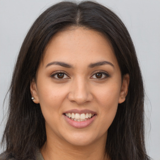 Joyful latino young-adult female with long  brown hair and brown eyes