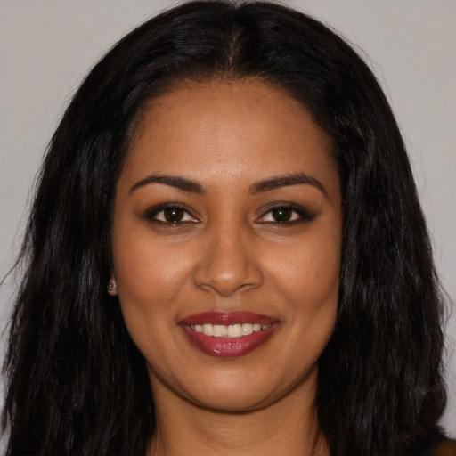 Joyful latino young-adult female with long  brown hair and brown eyes