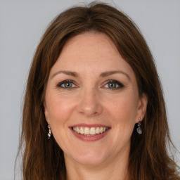 Joyful white adult female with long  brown hair and grey eyes