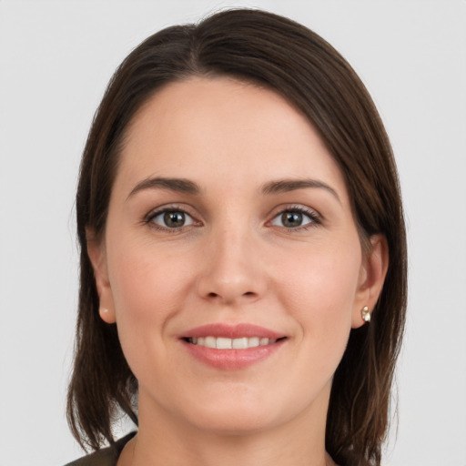 Joyful white young-adult female with medium  brown hair and grey eyes