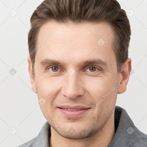 Joyful white young-adult male with short  brown hair and grey eyes