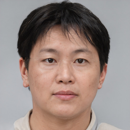Joyful asian adult male with short  brown hair and brown eyes