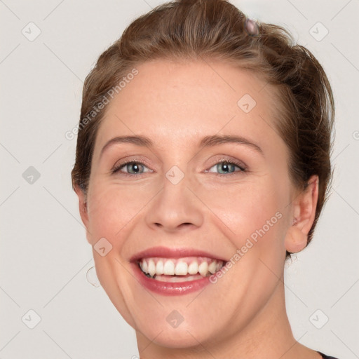 Joyful white young-adult female with short  brown hair and blue eyes