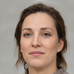 Joyful white adult female with medium  brown hair and brown eyes