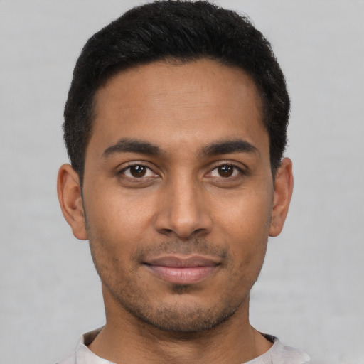 Joyful latino young-adult male with short  black hair and brown eyes