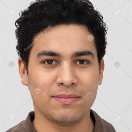 Joyful latino young-adult male with short  brown hair and brown eyes