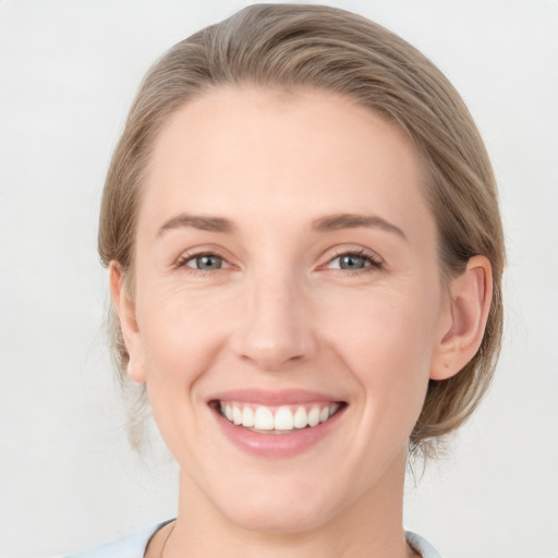 Joyful white young-adult female with medium  brown hair and blue eyes