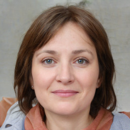 Joyful white young-adult female with medium  brown hair and blue eyes