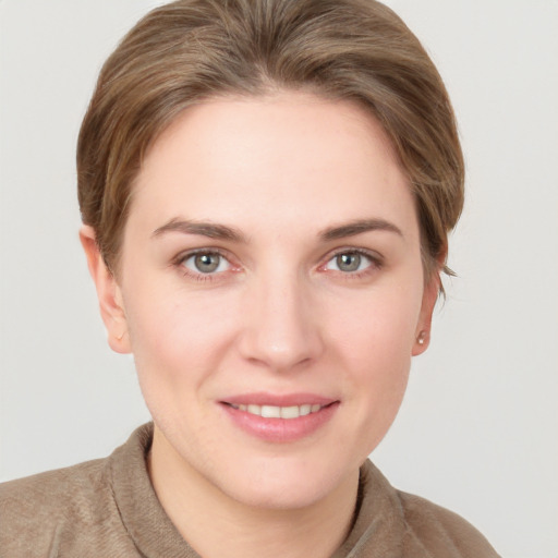 Joyful white young-adult female with short  brown hair and grey eyes