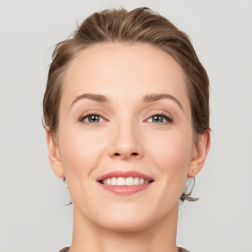 Joyful white young-adult female with medium  brown hair and grey eyes