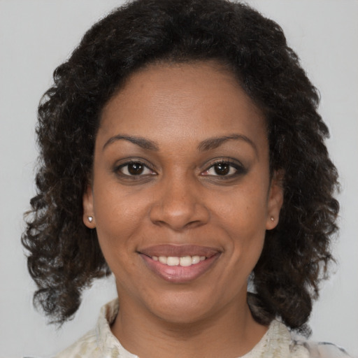 Joyful black adult female with medium  brown hair and brown eyes