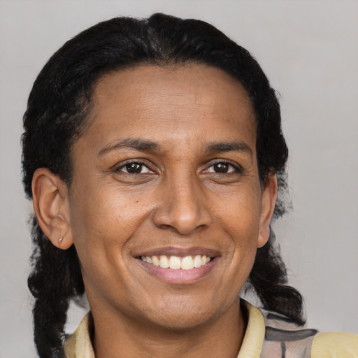 Joyful latino adult female with medium  brown hair and brown eyes