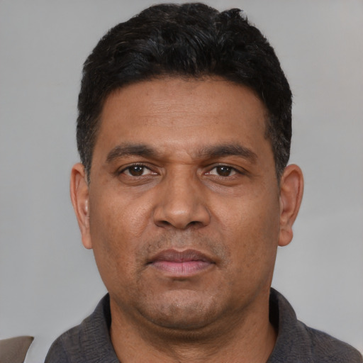 Neutral latino adult male with short  black hair and brown eyes