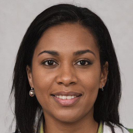 Joyful black young-adult female with long  brown hair and brown eyes