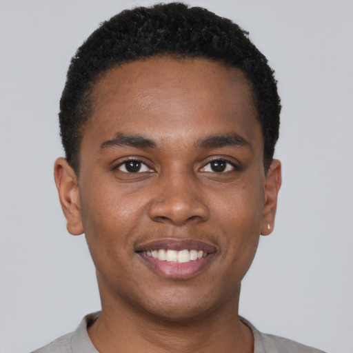 Joyful black young-adult male with short  brown hair and brown eyes