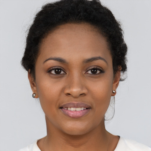 Joyful black young-adult female with short  brown hair and brown eyes