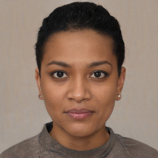 Joyful black young-adult female with short  black hair and brown eyes