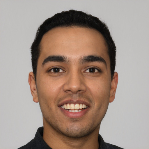 Joyful latino young-adult male with short  black hair and brown eyes